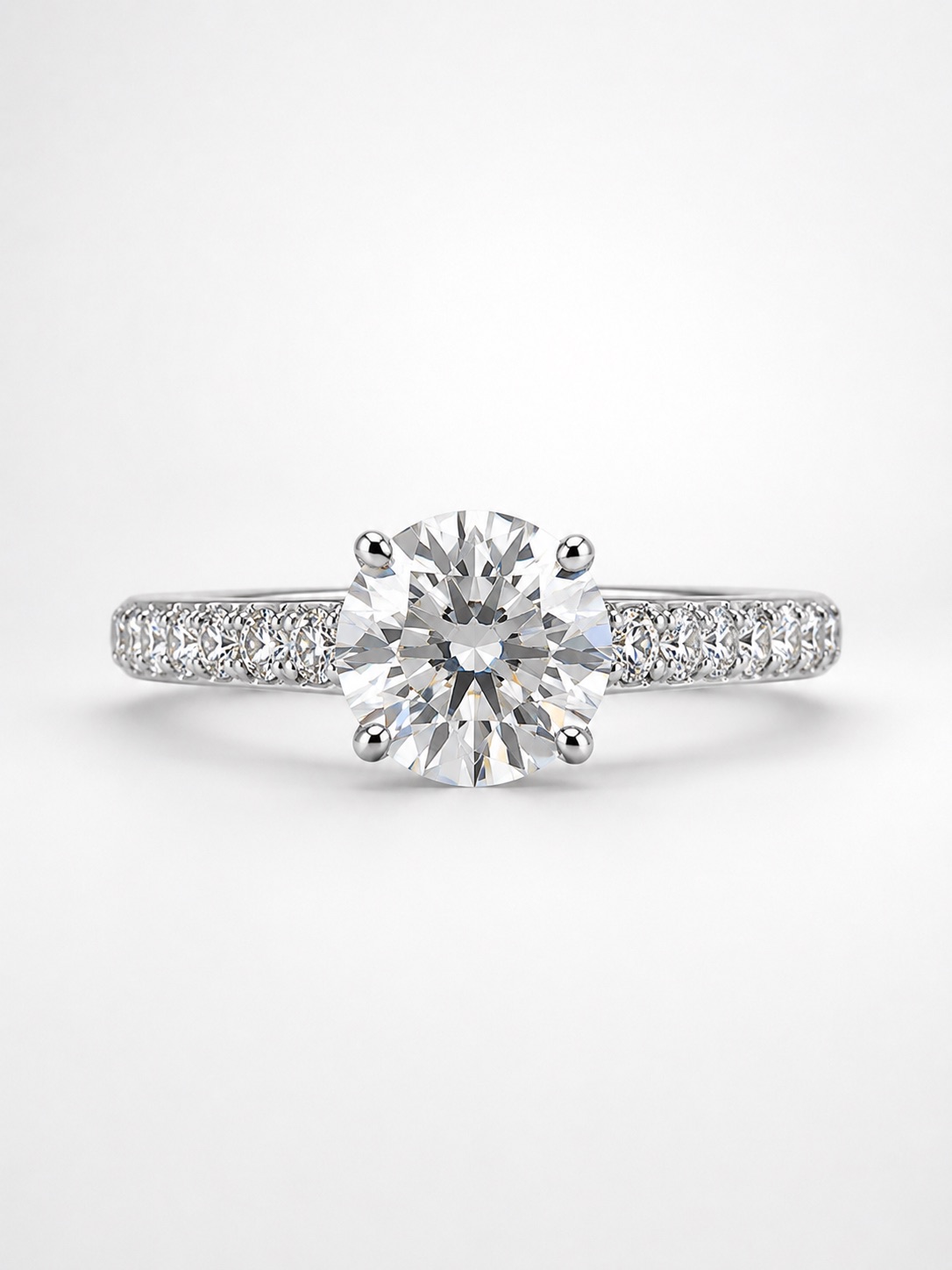 Bague de fiançailles en or blanc 18K : diamant rond central serti quatre griffes, anneau pavé de diamants.