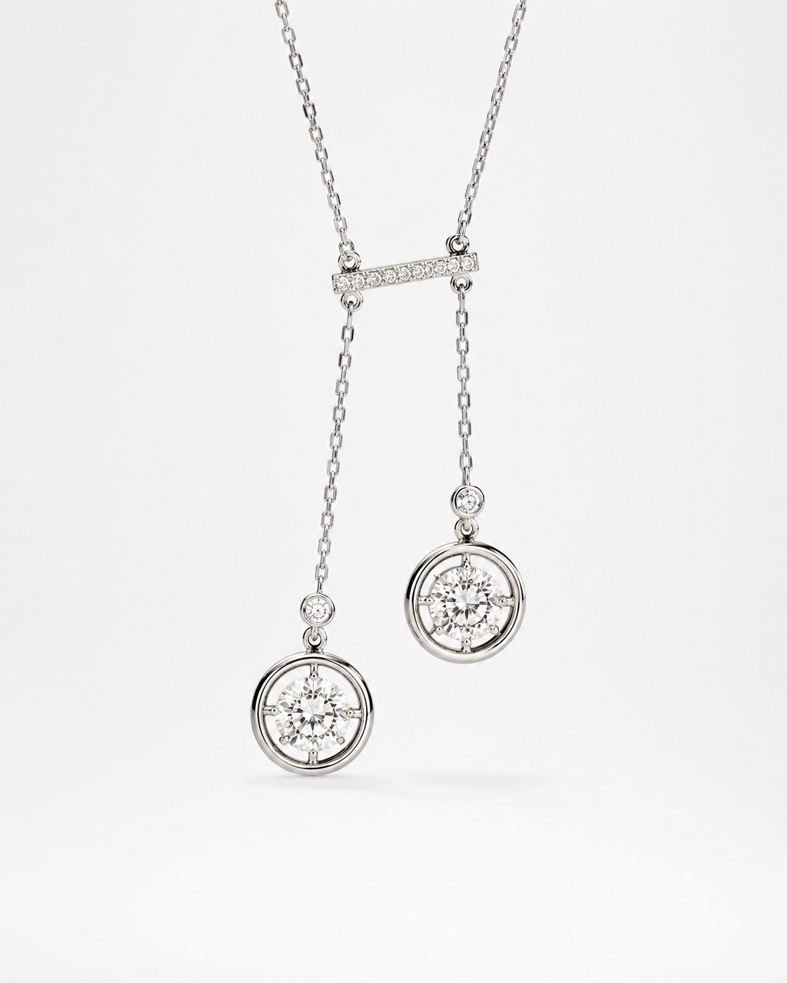 Collier en or blanc : barrette pavée de diamants et deux pendants ornés de diamants ronds en serti clos.
